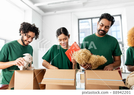 happy volunteers packing things in donation boxes happy volunteers packing things in donation boxes 88942201