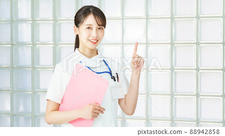 A woman in a white coat posing with her fingers raised A woman in a white coat posing with her fingers raised 88942858