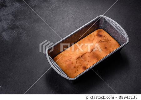 Baked rectangular cupcake with raisins and chocolate on a dark concrete background Baked rectangular cupcake with raisins and chocolate on a dark concrete background 88943135