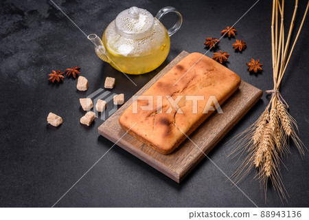 Baked rectangular cupcake with raisins and chocolate on a dark concrete background Baked rectangular cupcake with raisins and chocolate on a dark concrete background 88943136