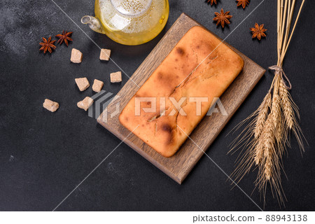 Baked rectangular cupcake with raisins and chocolate on a dark concrete background Baked rectangular cupcake with raisins and chocolate on a dark concrete background 88943138