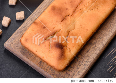 Baked rectangular cupcake with raisins and chocolate on a dark concrete background Baked rectangular cupcake with raisins and chocolate on a dark concrete background 88943139