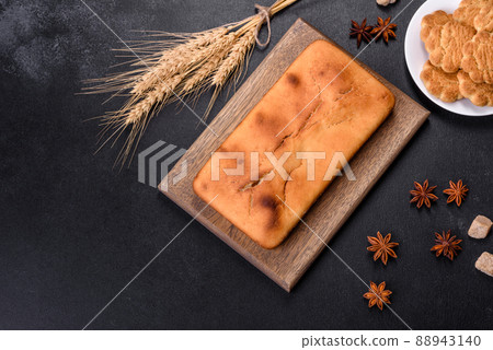 Baked rectangular cupcake with raisins and chocolate on a dark concrete background Baked rectangular cupcake with raisins and chocolate on a dark concrete background 88943140