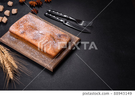 Baked rectangular cupcake with raisins and chocolate on a dark concrete background Baked rectangular cupcake with raisins and chocolate on a dark concrete background 88943149