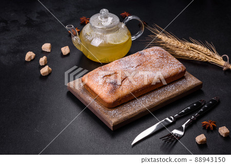 Baked rectangular cupcake with raisins and chocolate on a dark concrete background Baked rectangular cupcake with raisins and chocolate on a dark concrete background 88943150