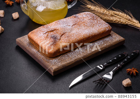 Baked rectangular cupcake with raisins and chocolate on a dark concrete background 88943155