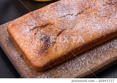 Baked rectangular cupcake with raisins and chocolate on a dark concrete background Baked rectangular cupcake with raisins and chocolate on a dark concrete background 88943157