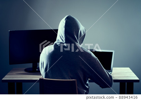 Male hacker writing code on a laptop 88943416