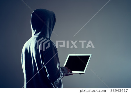 Male hacker writing code on a laptop 88943417