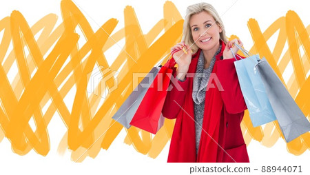 Caucasian woman holding shopping bags against yellow scribble on white background with copy space 88944071