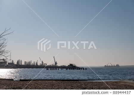 A dry cargo ship with open bilges is anchored in the middle of a wide river. A five-cargo ship in the outer waters of the Nikolaev seaport. A dry cargo ship with open bilges is anchored in the middle of a wide river. A five-cargo ship in the outer waters of the Nikolaev seaport. 88944437