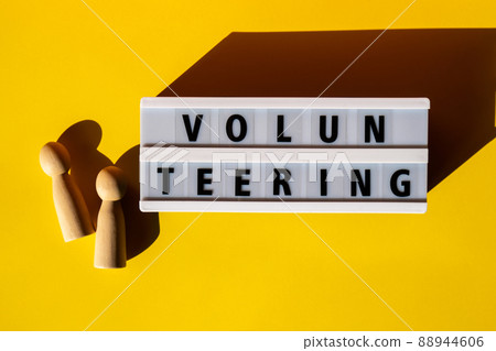 Lightbox with text VOLUNTEERING. Motivational Words Quotes Concept. Colorful yellow background. Minimalistic creative concept. Lightbox with text VOLUNTEERING. Motivational Words Quotes Concept. Colorful yellow background. Minimalistic creative concept. 88944606