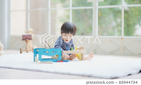 A 1 year and 10 month old boy playing with wooden toys 88944784