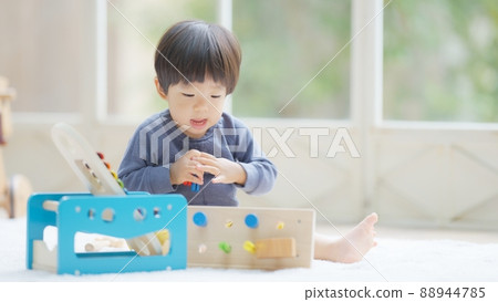 一個 1 歲 10 個月大的男孩在玩木製玩具 88944785