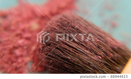 Closeup of the hair of brush head, covered with pink makeup powder, with a pile of pink cosmetic under the brush. Closeup of the hair of brush head, covered with pink makeup powder, with a pile of pink cosmetic under the brush. 88944815