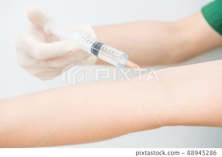 Cropped shot view of someone injecting themself with a syringe into a vein on the arm. Syringes are used for putting liquids into things. Cropped shot view of someone injecting themself with a syringe into a vein on the arm. Syringes are used for putting liquids into things. 88945286