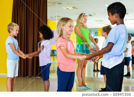 Group of children practicing vigorous jive movements in dance cl Group of children practicing vigorous jive movements in dance cl 88945300