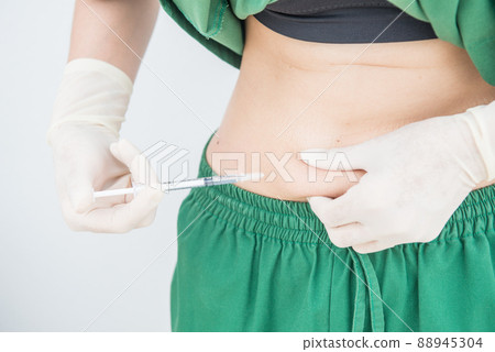 Shot of woman hand with syringe inject insulin to her belly. Diabetes injection and health care concepts. Shot of woman hand with syringe inject insulin to her belly. Diabetes injection and health care concepts. 88945304