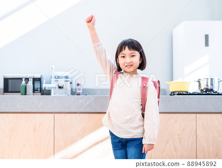 Elementary school student carrying a school bag in a guts pose Elementary school student carrying a school bag in a guts pose 88945892