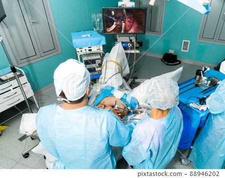 Doctors look at the monitor and operate on the patient. 88946202