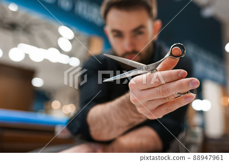 Handsome male hairdresser with scissors in hands	 88947961
