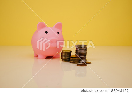 Pink piggy bank with stack of coins on yellow background. Savings concept Pink piggy bank with stack of coins on yellow background. Savings concept 88948152