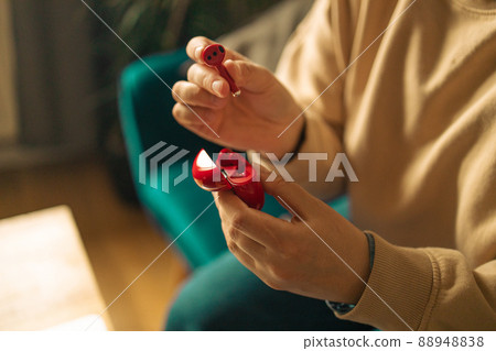 freelancer woman hands with red wireless earphones stay home sit cozy couch living room indoors freelancer woman hands with red wireless earphones stay home sit cozy couch living room indoors 88948838