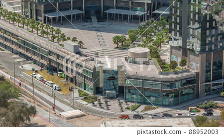 Rooftop garden with palms near entrance to office towers in financial district of Dubai city timelapse Rooftop garden with palms near entrance to office towers in financial district of Dubai city timelapse 88952003