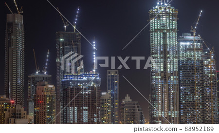 High multi-storey buildings under construction and cranes at night timelapse 88952189