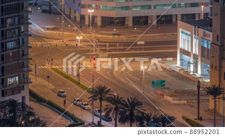 Aerial view of intersection with many transports in traffic and parking night timelapse in Dubai Downtown 88952201