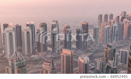 JLT skyscrapers and marina towers near Sheikh Zayed Road aerial timelapse during sunrise. Residential buildings JLT skyscrapers and marina towers near Sheikh Zayed Road aerial timelapse during sunrise. Residential buildings 88952491