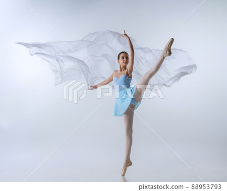 One young girl, aspiring ballerina in blue dress and pointes dancing with cloth isolated on gray background. Art, grace, beauty, ballet school concept 88953793