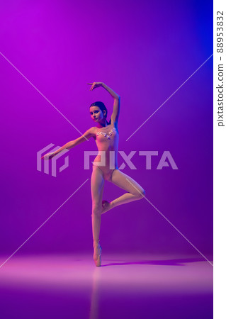 Portrait of young little ballet dancer, teen practicing, dancing isolated on purple background in neon light. Art, grace, beauty, ballet school concept Portrait of young little ballet dancer, teen practicing, dancing isolated on purple background in neon light. Art, grace, beauty, ballet school concept 88953832