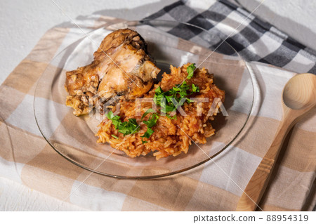 Bowl of east African Jollof Rice garnished with pieces of roasted chicken 88954319
