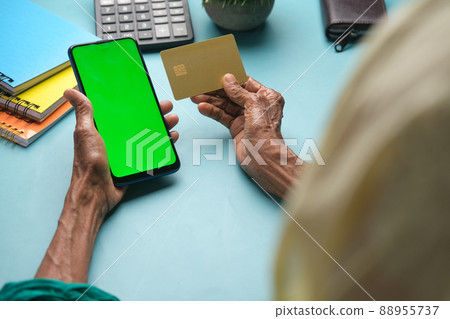 senior women hand holding credit card and using smart phone shopping online senior women hand holding credit card and using smart phone shopping online 88955737