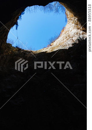 view from the cave to the blue sky. a natural well on slope of Mount. view from the cave to the blue sky. a natural well on slope of Mount. 88955818