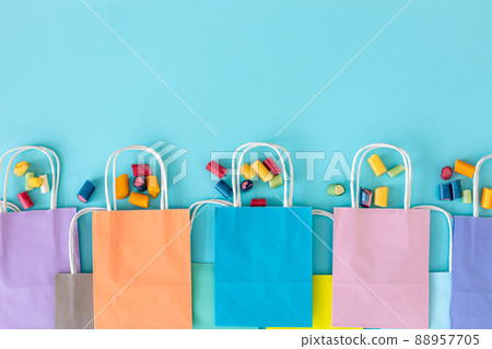 Flat lay, paper bags and chewing gummies on a blue background. 88957705