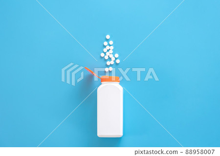 Pills are poured out of a jar on a blue background., flat lay. Pills are poured out of a jar on a blue background., flat lay. 88958007
