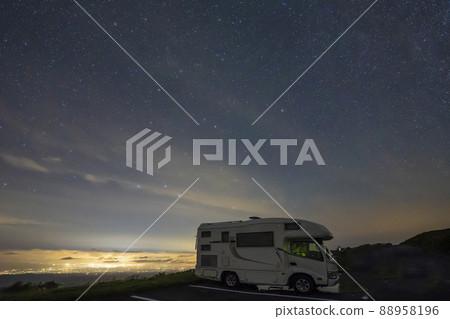 星空和雲海下被城市燈光照亮的露營車 星空和雲海下被城市燈光照亮的露營車 88958196