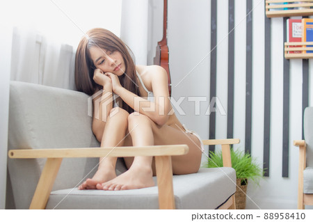 Portrait young smile happy beautiful asian woman relax bedroom. woman with headphones playing acoustic guitar in white bedroom 88958410