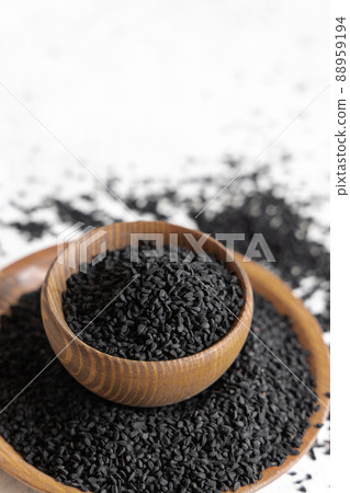 Indian spice Black cumin (nigella sativa or kalonji) seeds in wooden bowls close up Indian spice Black cumin (nigella sativa or kalonji) seeds in wooden bowls close up 88959194