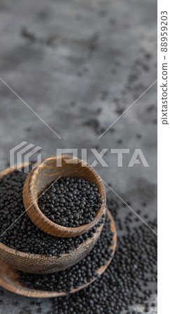 Wooden bowls of dry black lentils beans on grey table close up, protein source for vegetarian diet 88959203