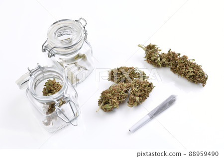 Medical cannabis flowers and marijuana joint on white table and in containers in clean laboratory  88959490
