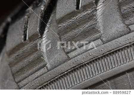 Old worn black tire with many large cracks in the car wheel. Old worn black tire with many large cracks in the car wheel. 88959827