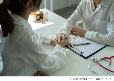 Asian female doctor in white medical uniform consult female patient in private hospital. woman therapist speak talk with woman client on consultation in clinic Asian female doctor in white medical uniform consult female patient in private hospital. woman therapist speak talk with woman client on consultation in clinic 88960685