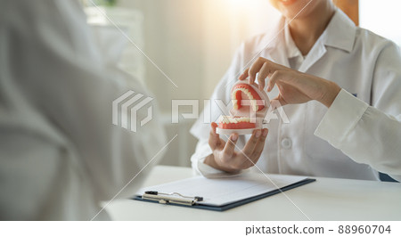 dentist and patient discussion about planned teeth treatment in dental clinic office - dentist consultation concept dentist and patient discussion about planned teeth treatment in dental clinic office - dentist consultation concept 88960704