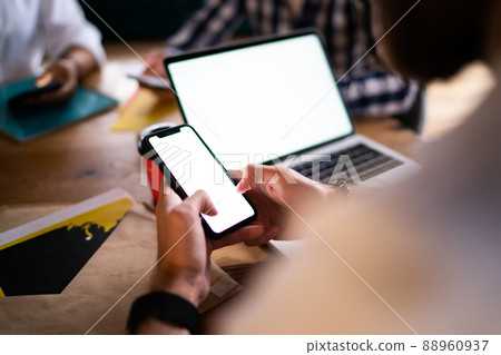 Unrecognizable blogger networking and texting on blank cellphone Unrecognizable blogger networking and texting on blank cellphone 88960937