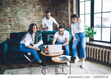 Pensive friends sitting at sofa and using laptop Pensive friends sitting at sofa and using laptop 88960938