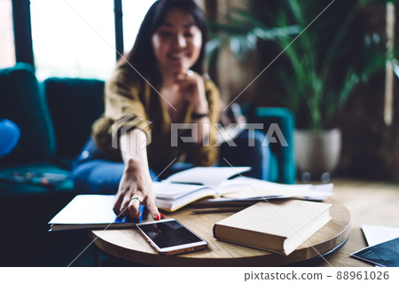 Selective focus on modern cellphone gadget used by blurred female student Selective focus on modern cellphone gadget used by blurred female student 88961026