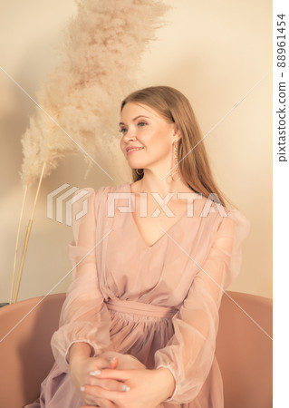 girl in pastel-colored dress sits on chair and looks away 88961454